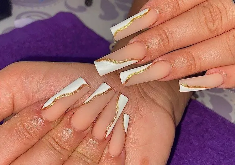 långa vita och guldfärgade naglar