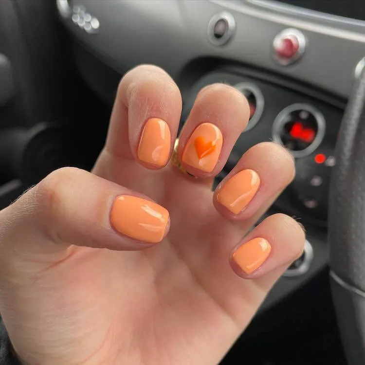 하트가있는 밝은 주황색 손톱