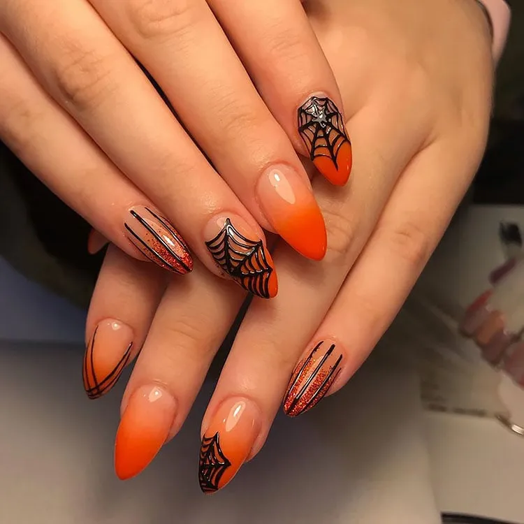 uñas naranja con tela de araña negra